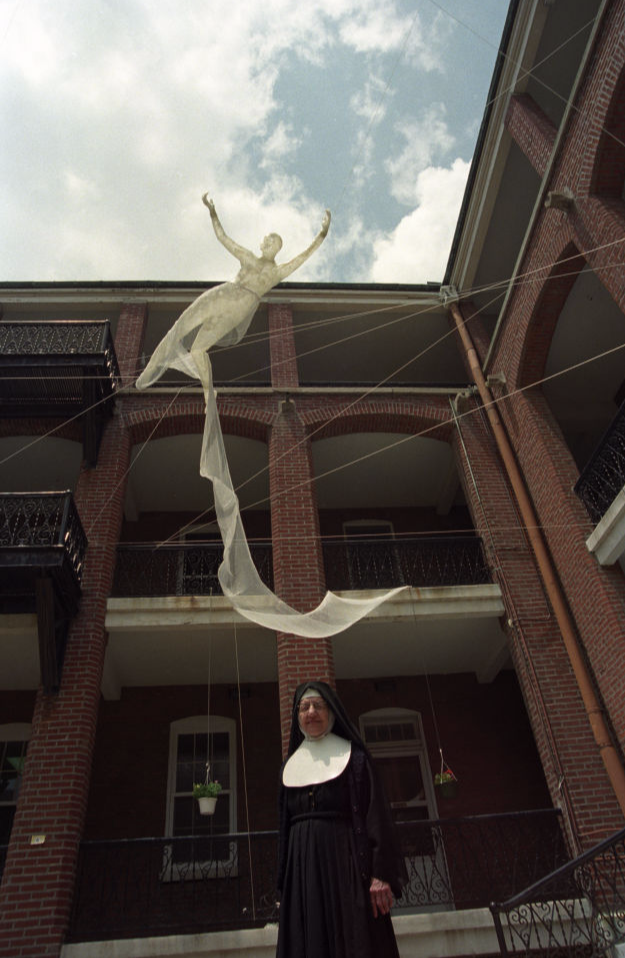 Nun in front of sculpture.